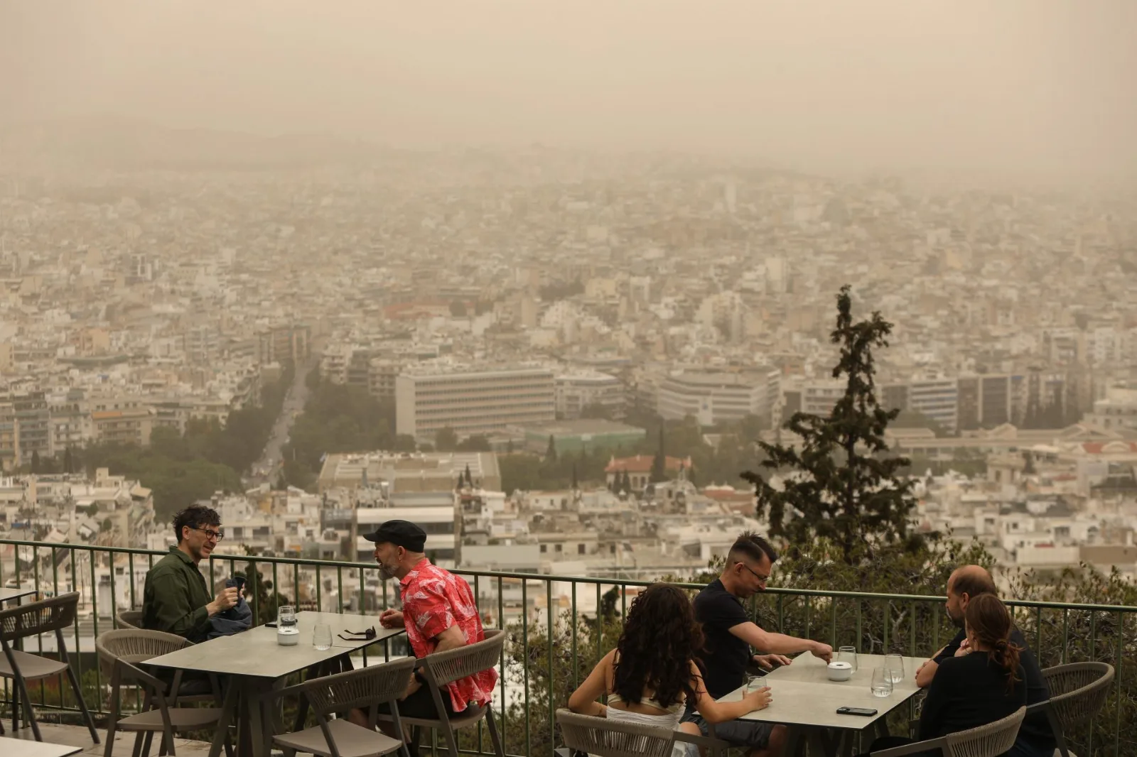 Cielo anaranjado cargado de polvo sahariano sobre una ciudad europea con paneles solares al fondo